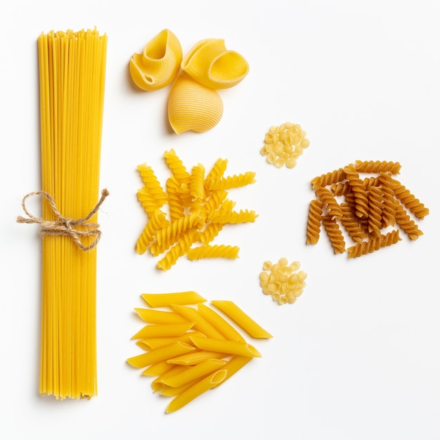 Spaghetti et pâtes italiennes crues sur fond blanc