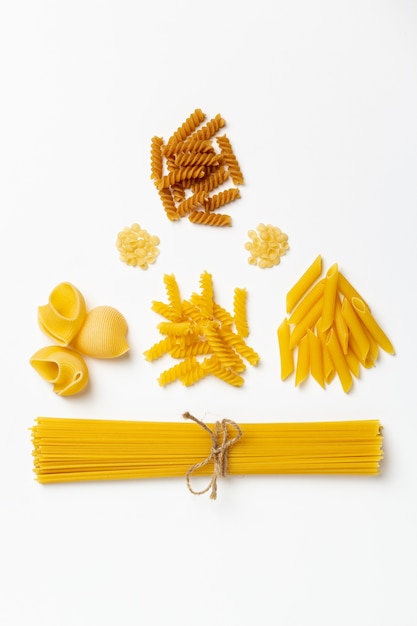 Spaghetti et pâtes italiennes crues sur fond blanc