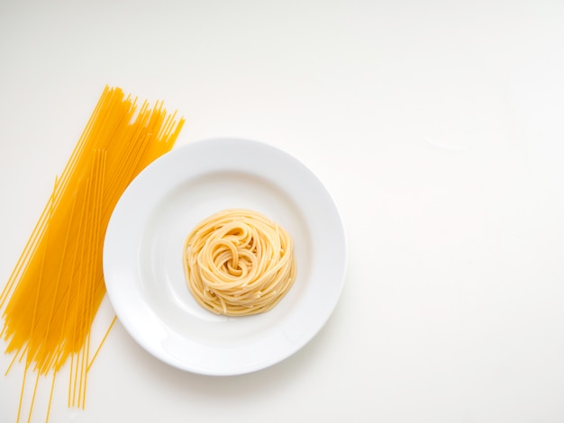 Spaghetti, pâtes sur plaque sur fond blanc