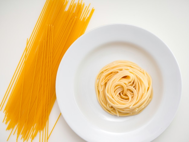 Spaghetti, pâtes sur plaque sur fond blanc