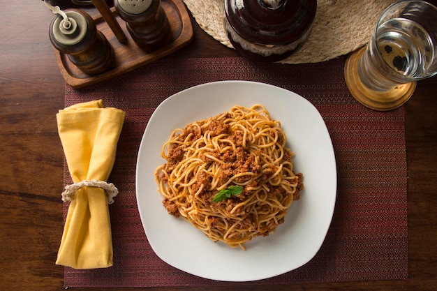 Spaghetti sauce bolognaise viande hachée Pérou nourriture réconfortante péruvienne mise en place table en bois
