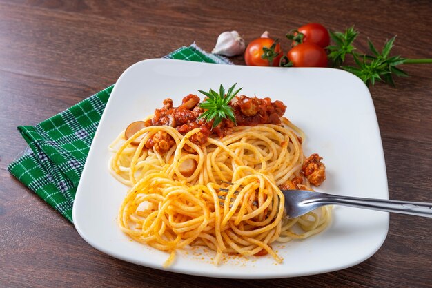 Spaghetti à la sauce dans le plat sur la table en bois