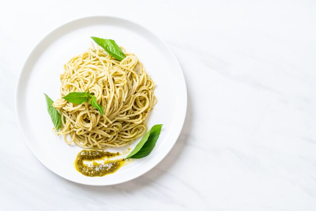 spaghetti à la sauce pesto, huile d'olive et feuilles de basilic.