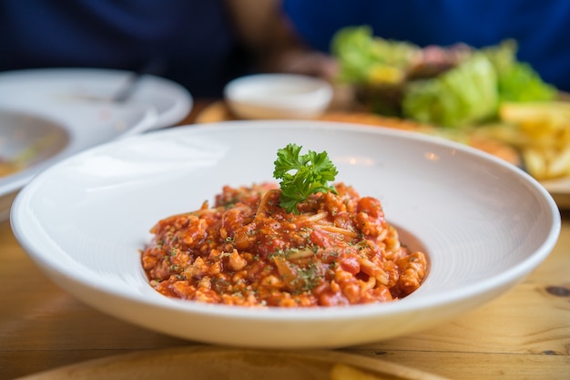 Spaghetti à la sauce tomate de porc hachée sur un plat blanc au restaurant