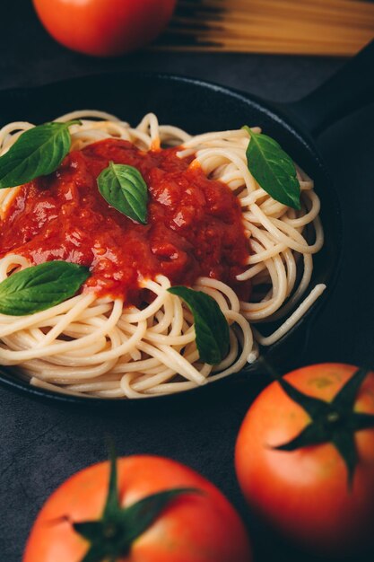 Spaghetti à la sauce tomate et viande hachée Parmesan et basilic Fond noir