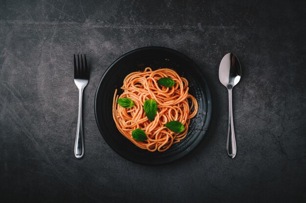 Spaghetti à la sauce tomate et viande hachée Parmesan et basilic Fond noir