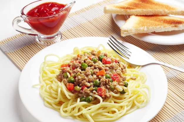 Spaghetti à la viande hachée et aux légumes sur table