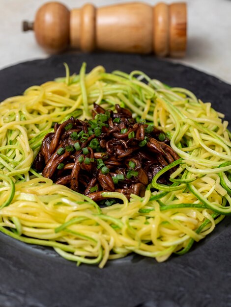 Spaghettis aux courgettes avec shimeji sur plaque de pierre noire