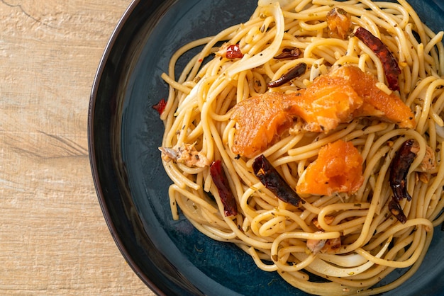 Photo spaghettis frits avec du saumon et du piment sec