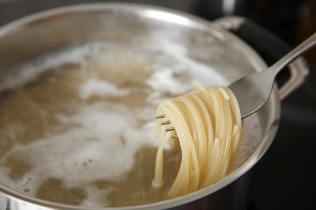 Des spaghettis roulés sur une fourchette sur une casserole