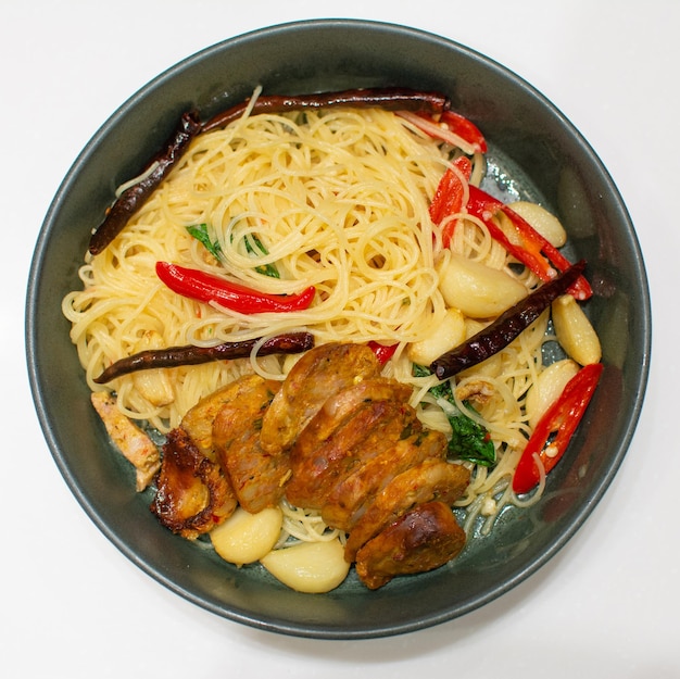 Spaghettis avec des saucisses épicées du nord de la Thaïlande sur fond blanc