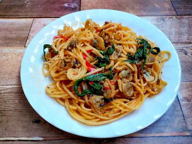 Spaghettis sautés aux palourdes sur une table en bois