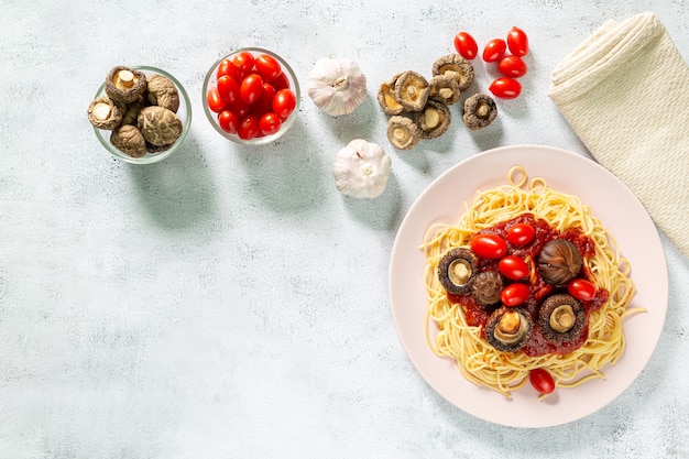 spaghettiVue de dessus de la plaque avec des spaghettis à la sauce tomate et basilic sur fond blanc