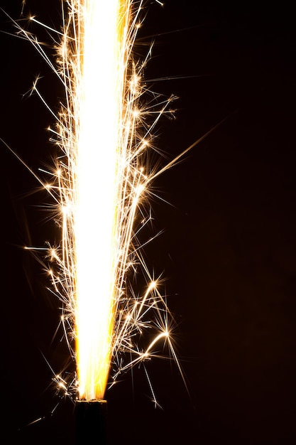 Sparkler background Un sparkler est un type de feu d'artifice à main qui brûle lentement tout en émettant des étincelles de flammes colorées et d'autres effets