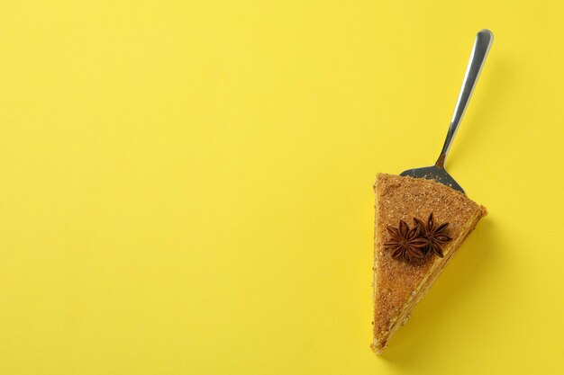 Spatule à gâteau avec gâteau au miel sur fond jaune