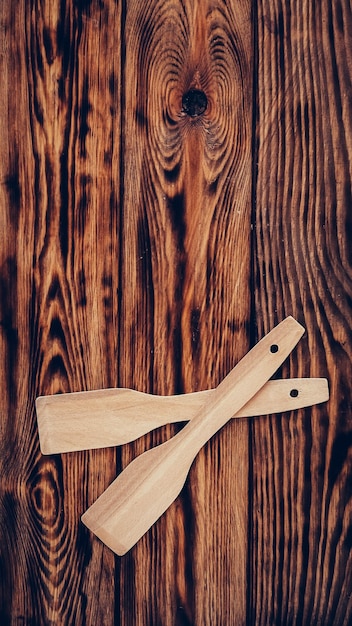 Spatules de cuisine en bois sur fond de table marron