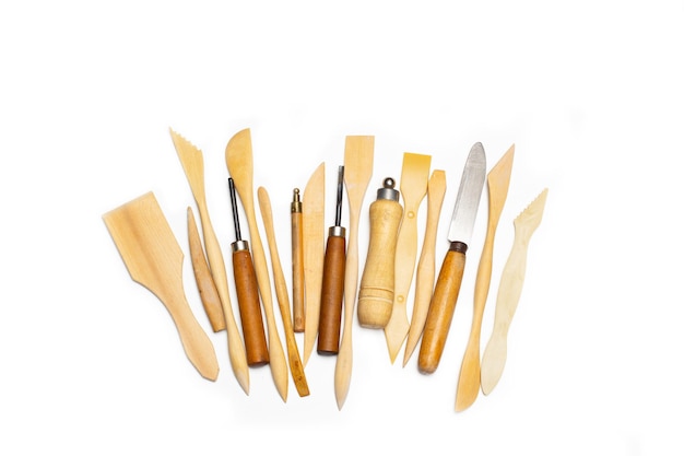 Spatules de poterie en bois gouges et poinçons sur fond blanc avec espace de copie