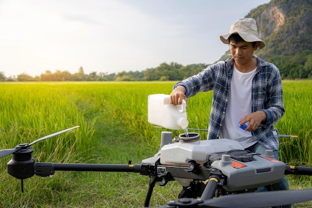 Un spécialiste de l'agriculture ou un Famer remplit des engrais chimiques dans un drone agricole Agriculture 5g Concept de technologie intelligente d'agriculture intelligente