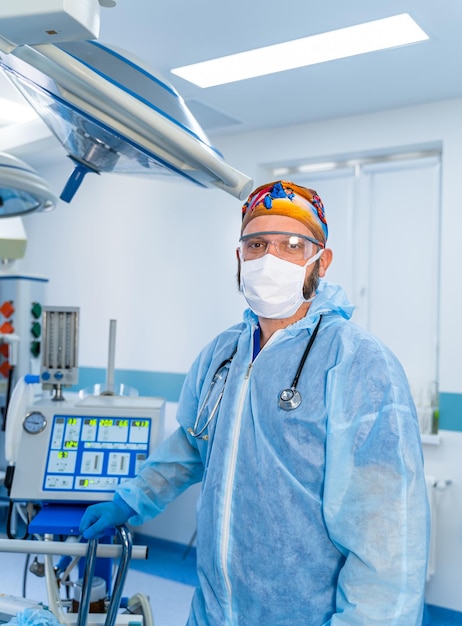 Spécialiste de la chirurgie professionnelle en uniforme médical et masque Médecin de sexe masculin en uniforme bleu et masque médical de protection