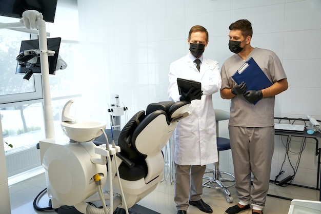Spécialistes dentaires occupés utilisant des masques de protection au travail