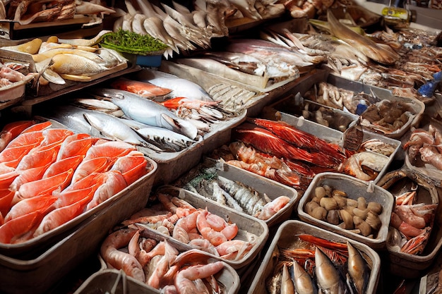 Des spécialités de fruits de mer disposées dans des bols sur le comptoir du marché aux poissons