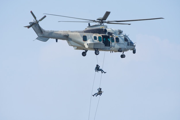 Spectacle des forces spéciales avec un soldat ou un pilote saute d'un hélicoptère avec un ciel bleu