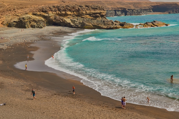 Spectaculaire plage de sable noir et montagnes avec criques en arrière-plan à Ajuy, Fuerteventura, îles Canaries, Espagne