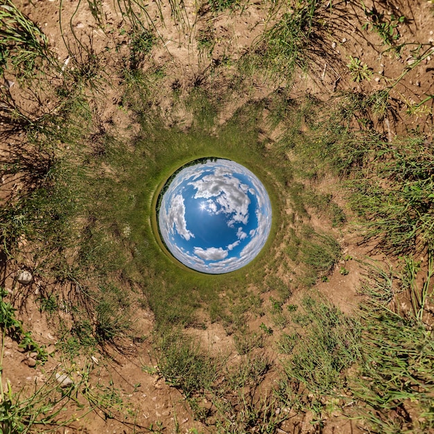 Photo sphère bleue petite planète à l'intérieur de l'herbe verte fond de cadre rond