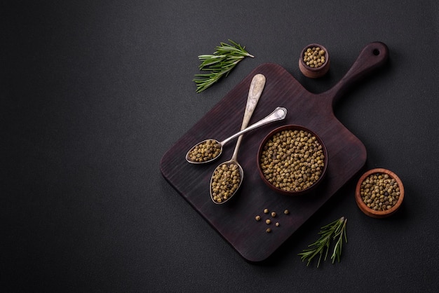 Spice piment vert dans un bol en bois sur un fond de béton noir