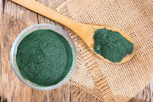 Spiruline en poudre d'algues sur fond de bois