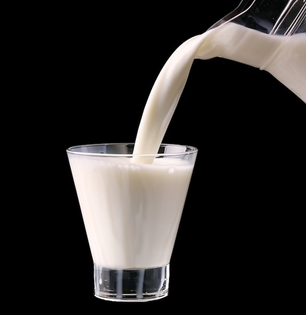 Splash dans un verre avec du lait isolé sur fond noir