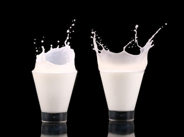 Splash dans un verre avec du lait isolé sur fond noir