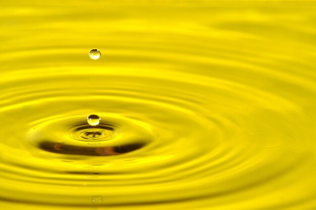 Splash goutte d'eau avec des cercles d'eau divergents sur fond jaune