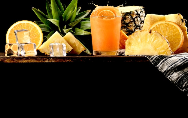 Photo splash jus d'orange et fond d'ananas, espace copie