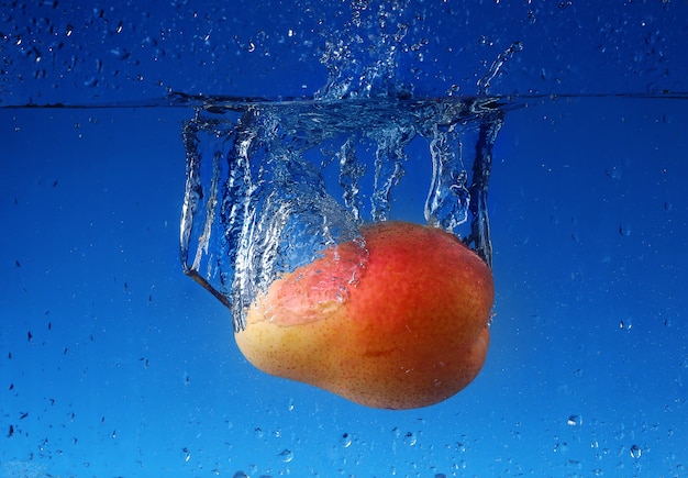 Splash avec poire sur un mur bleu