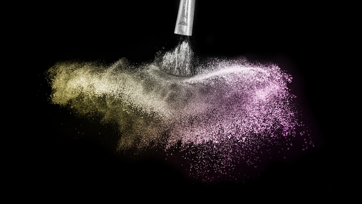 Photo splash poudre or et violet et pinceau pour le maquillage