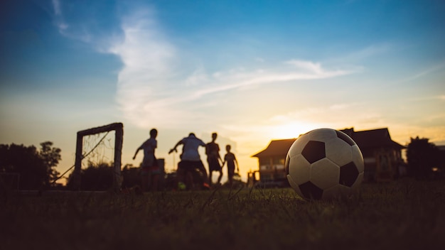 Sport d'action silhouette à l'extérieur des enfants s'amusant à jouer au football football