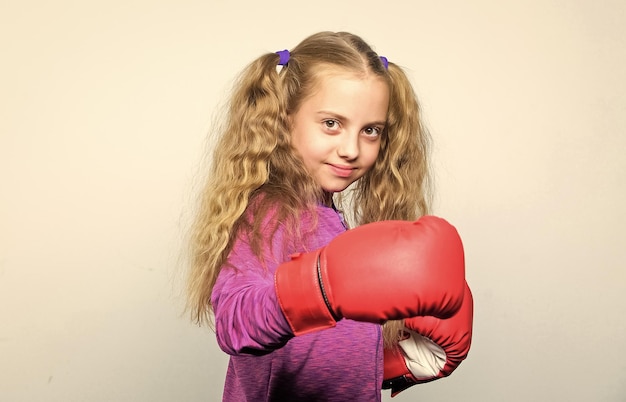 Photo sport de boxe pour femme compétence d'un leader réussi éducation sportive fille enfant mignon avec des gants rouges posant sur fond blanc éducation pour leader boxe enfant fort concept sport et santé