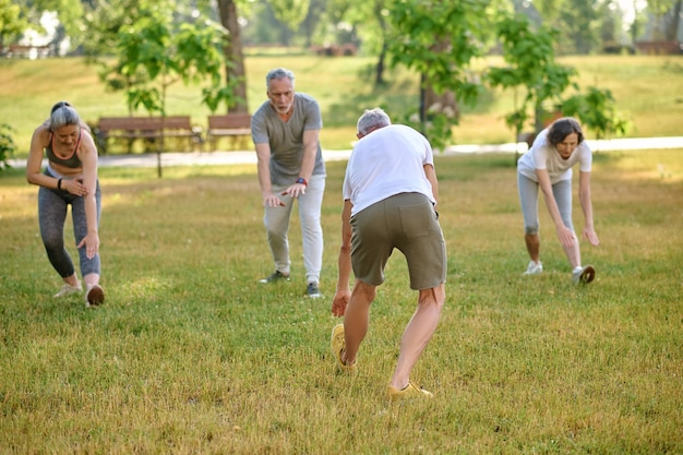 Sport dans le parc Groupe de personnes matures faisant de l'exercice en plein air Mode de vie sain Étirement du corps avant l'entraînement