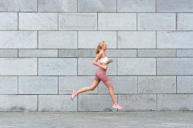 Le sport dit de continuer à avancer Une sportive sexy court à l'extérieur Profiter d'activités sportives