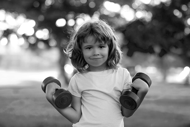 Sport enfant garçon avec des muscles biceps forts enfants exerçant des haltères fitness fort petit garçon exerc