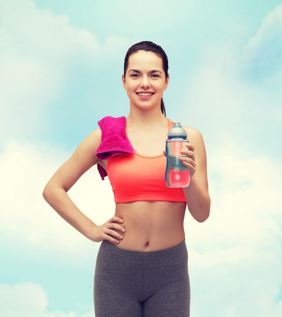 sport, exercice et soins de santé - femme sportive avec une serviette rose et une bouteille d'eau