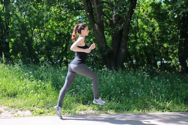 Sport femme courir dans le parc en plein air