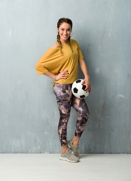 Sport Femme Sur Mur Grunge Tenant Un Ballon De Foot