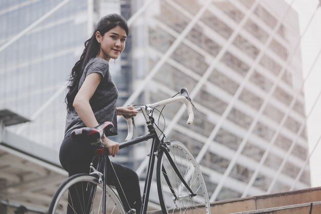 Sport femme porte son vélo dans l&#39;escalier