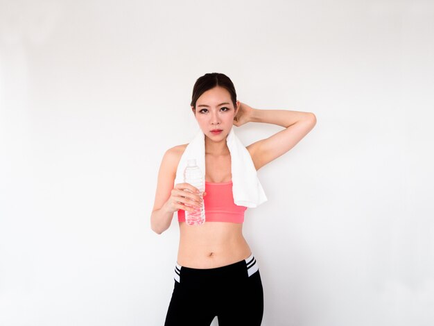 Sport femme tenant une nappe de sueur blanche et de l&#39;eau sur le cou, concept de remise en forme