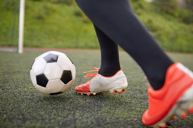 Photo sport, football et peuple - joueur de football jouant avec le ballon sur le terrain