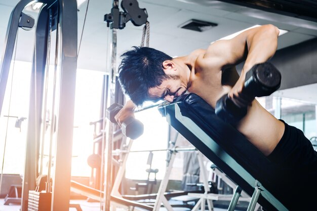 Sport Man Gardez les vêtements calmes dans la salle de gym avec des poids