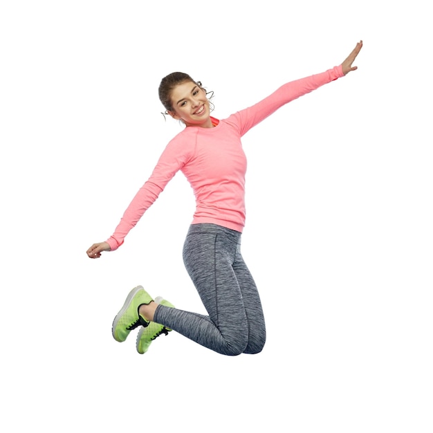 sport, remise en forme, mouvement et concept de personnes - jeune femme souriante heureuse sautant en l'air sur un fond blanc