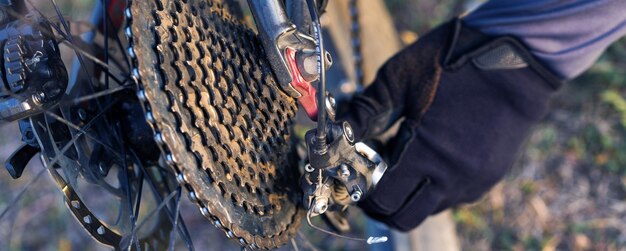 Sportif barbu brutal sur un vélo de montagne moderne Un cycliste dans les collines verdoyantes répare un vélo